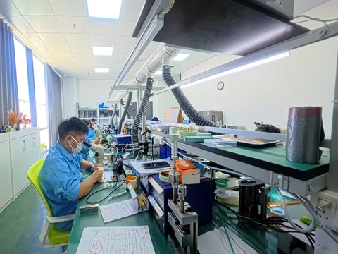 调试与老化区,作业人员在车间工位上作业